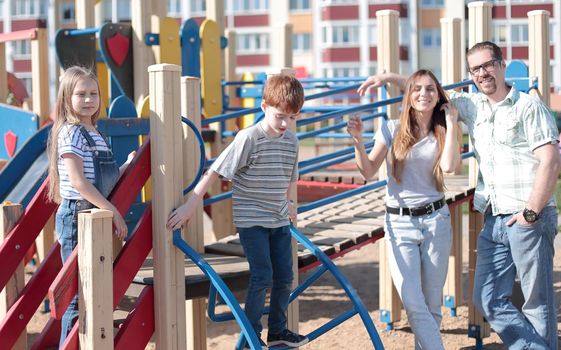 happy family standing in the courtyard of a new residential complex. the concept of parenting