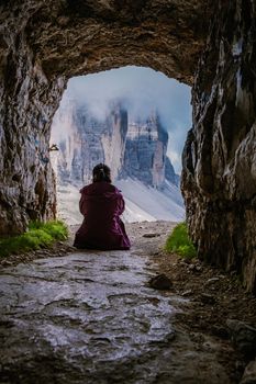 Tre Cime di Lavaredo peaks or Drei Zinnen at sunset, Dobbiaco Toblach, Trentino -Alto Adige or South Tyrol, Italy. Europe Alps. Asian woman hiking in the mountains