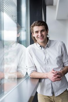 portrait of young businessman at startup office by the window