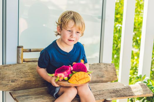 Diced dragon fruit and mango in the hands of the boy.