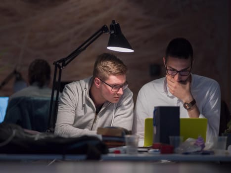 young designers working on a new project in the night startup office using modern technology