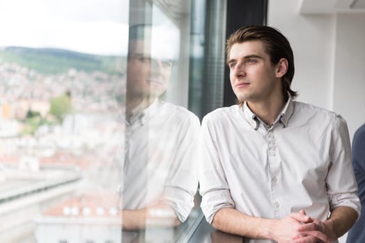 portrait of young businessman at startup office by the window