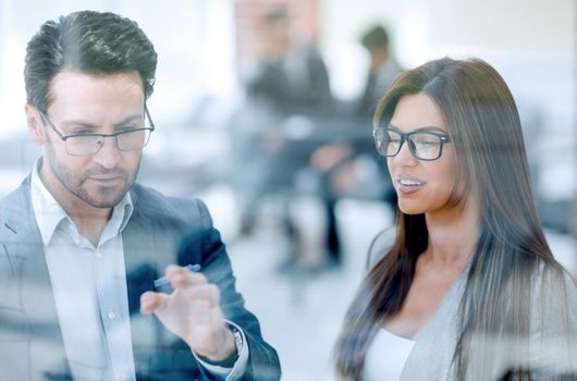 close up.business partners discussing something while standing near the office window