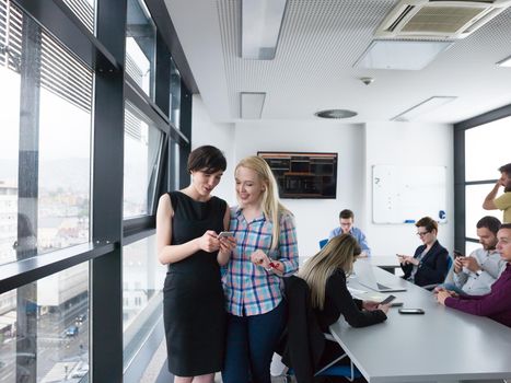 two female managers using cell telephone in office interior