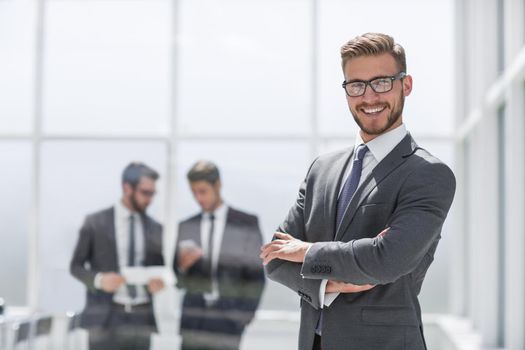 smiling businessman on blurred office background.photo with text space