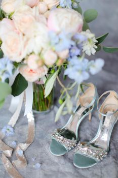 Closeup female shoes on high heels near bouquet of flower. Concept of wedding and bridal accesories.