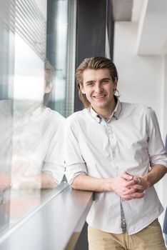 portrait of young businessman at startup office by the window