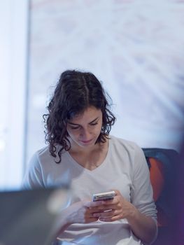 Businesswoman typing on phone while browsing internet at work in office