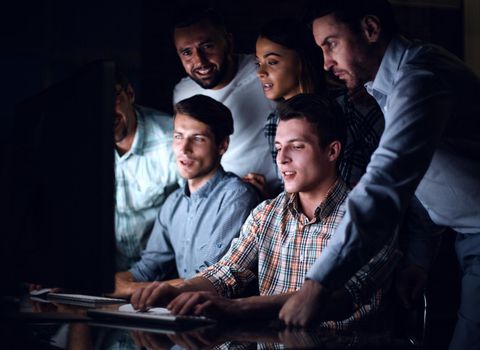 business team looks closely at the computer monitor . photo with text space