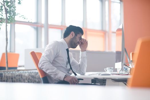 frustrated young business man working on desktop  computer at modern startup office interior