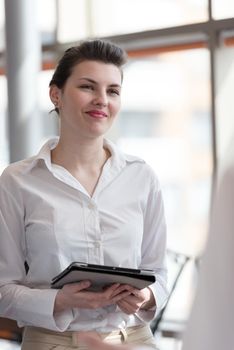 portrait of young business woman with tablet computer at modern office interior