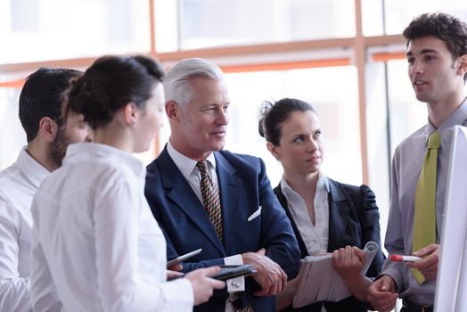 young startup businessman making presentation of project to senior investior, group of business people taking notes and make plans on white  flip board and tablet computer