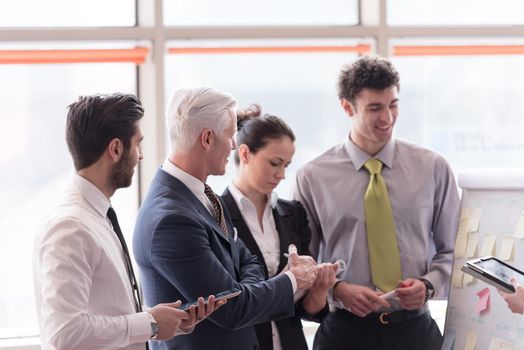 young startup businessman making presentation of project to senior investior, group of business people taking notes and make plans on white  flip board and tablet computer