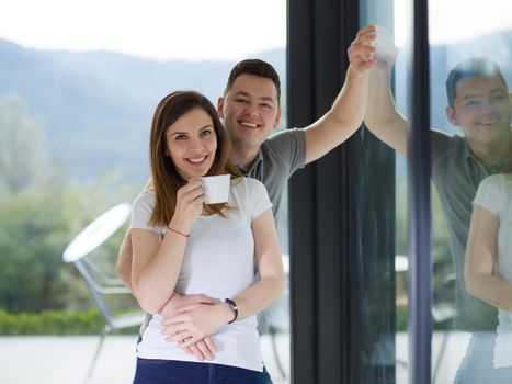 romantic happy young couple enjoying morning coffee by the window in their luxury home