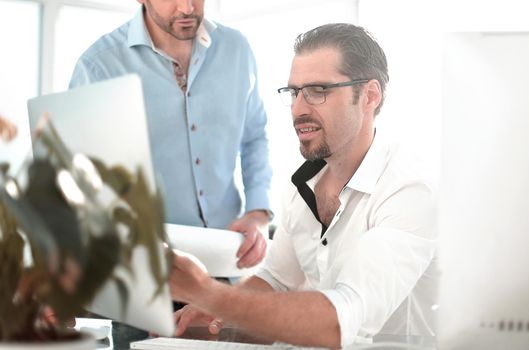 background image.Two serious businessmen talking and working in the office