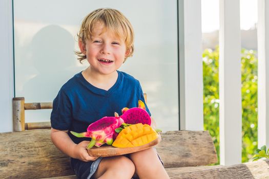 Diced dragon fruit and mango in the hands of the boy.