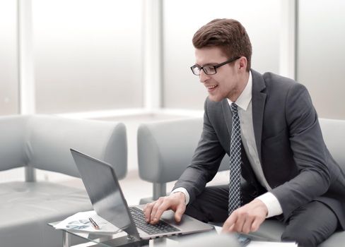 close up.smiling businessman using laptop and calculator. accounting and technology