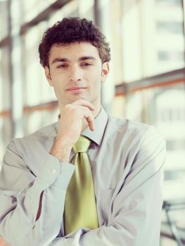 portrait of young business man at modern office  interior with big windows in background