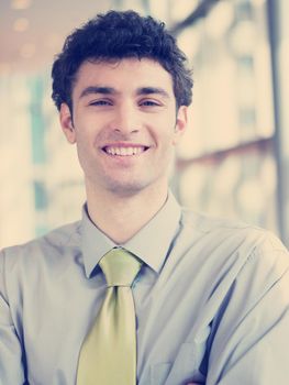 portrait of young business man at modern office  interior with big windows in background