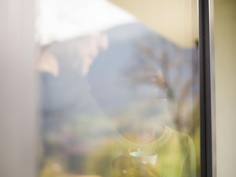 romantic happy young multiethnic couple enjoying morning coffee by the window in their luxury home