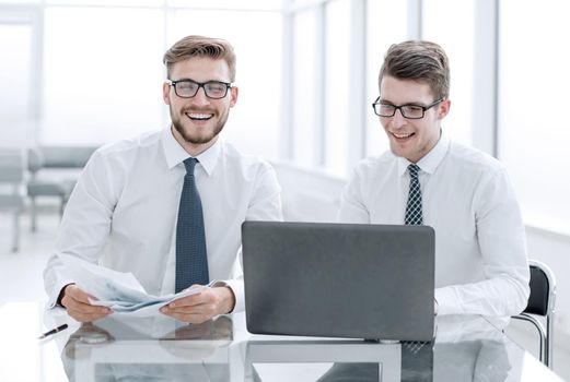 happy employees sitting at a table in a new office.people and technology