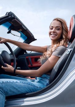 close up.stylish young woman sitting in a luxury car .side view