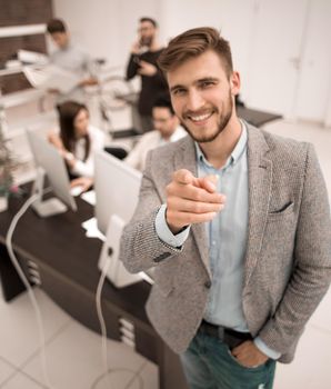 young businessman standing in the office and pointing at you.the concept of choice