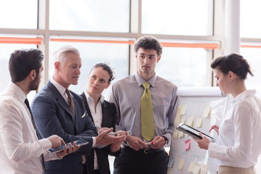 young startup businessman making presentation of project to senior investior, group of business people taking notes and make plans on white  flip board and tablet computer