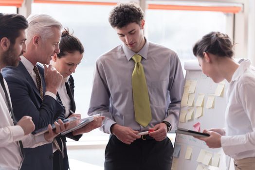 young startup businessman making presentation of project to senior investior, group of business people taking notes and make plans on white  flip board and tablet computer