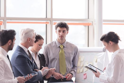 young startup businessman making presentation of project to senior investior, group of business people taking notes and make plans on white  flip board and tablet computer