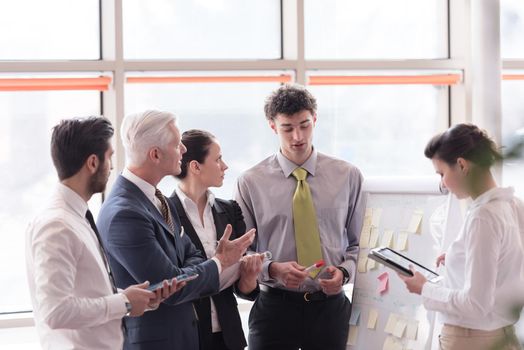 young startup businessman making presentation of project to senior investior, group of business people taking notes and make plans on white  flip board and tablet computer