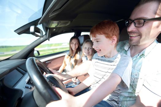 funny father and his little son driving a car .the concept of parenting