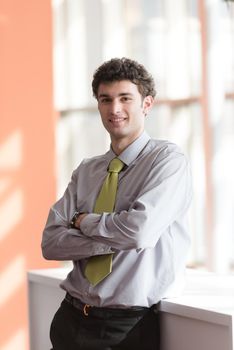 portrait of successful young business man at modern office  interior with big windows in background