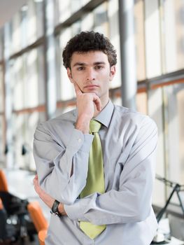 portrait of young business man at modern office  interior with big windows in background