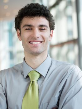 portrait of young business man at modern office  interior with big windows in background