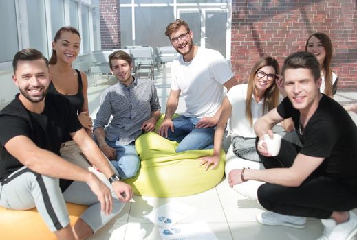 group of creative young people sitting on the floor in the new office.photo with copy space