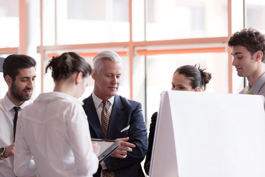 young startup businessman making presentation of project to senior investior, group of business people taking notes and make plans on white  flip board and tablet computer