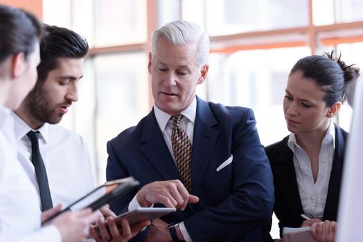 young startup businessman making presentation of project to senior investior, group of business people taking notes and make plans on white  flip board and tablet computer