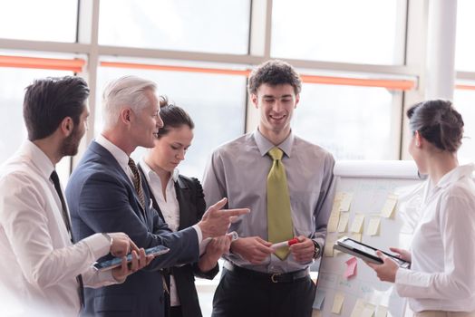 young startup businessman making presentation of project to senior investior, group of business people taking notes and make plans on white  flip board and tablet computer