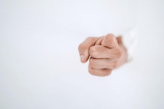 man's hand breaking through the paper wall and pointing at you .photo with copy space