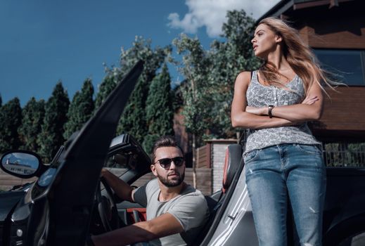 young couple standing near luxury car.the concept of a successful lifestyle