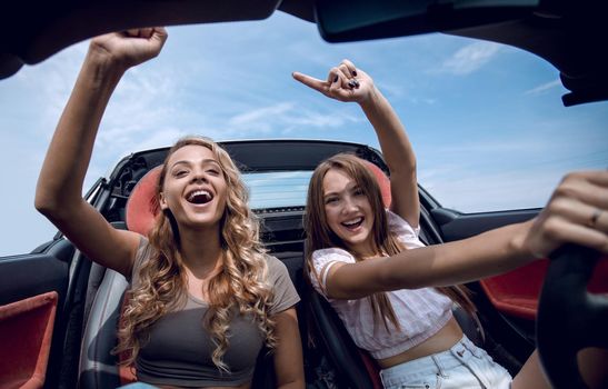 two girlfriends enjoying a trip in the car.the freedom of the open road