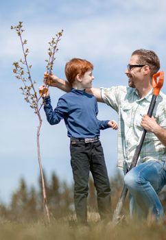 happy father and son planted a tree together. photo with copy space