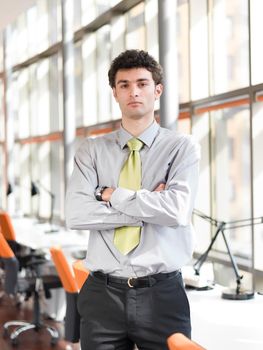 portrait of young business man at modern office  interior with big windows in background