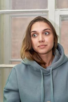 Facial portrait of a young beautiful girl in a sweatshirt with a hood. Close up