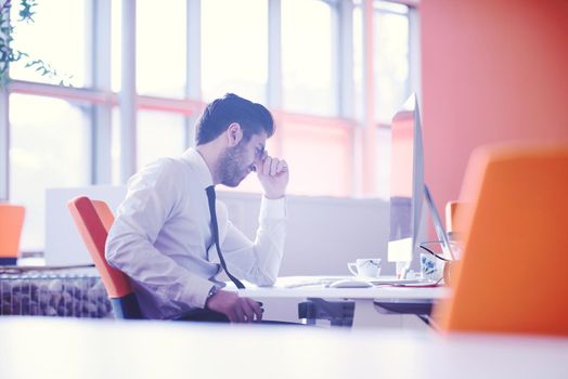 frustrated young business man working on desktop  computer at modern startup office interior