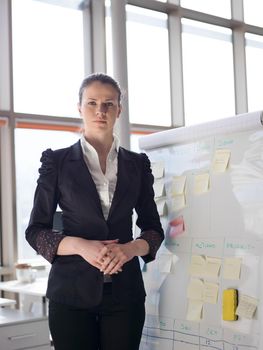 portrait of young business woman at modern office with flip board  and big window in background