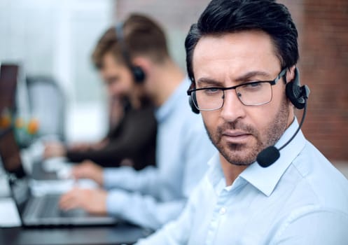 close up.call center operator on the background of the office.business concept