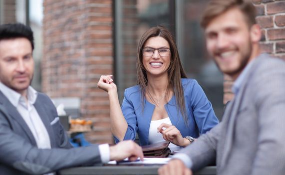 employees of the company sitting at a table in a street cafe.the concept of teamwork