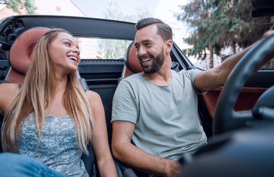 close up.beautiful couple sitting in the front seat of a convertible.travel together